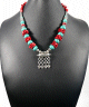 Collier ethnique artisanal avec pierres turquoises et rouge agremente de breloques et d'armatures argentees